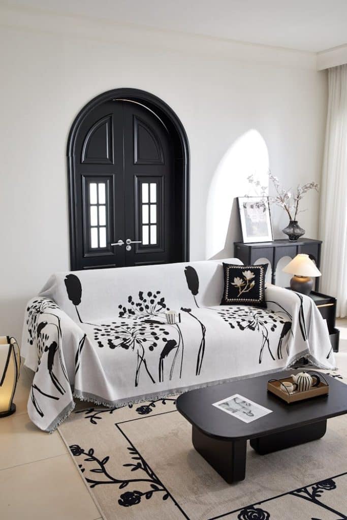 Stylish black and white living room interior with sofa, table, and decor elements.